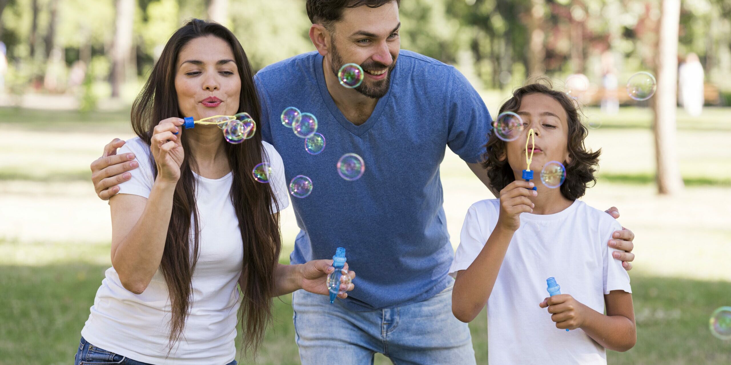 padres-nino-pasando-buen-rato-soplando-burbujas-parque