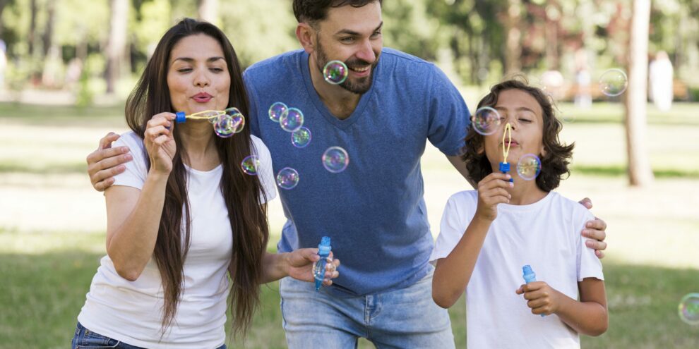 padres-nino-pasando-buen-rato-soplando-burbujas-parque padres-nino-pasando-buen-rato-soplando-burbujas-parque