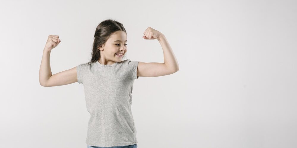 junior-girl-showing-muscles-studio