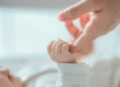 Bebé sujetando el dedo índice de un adulto